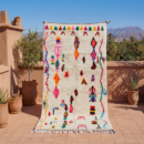 Detail eines Azilal Teppichs mit pinkem, orangefarbenem und schwarzem Berber-Muster auf cremefarbener Wolle