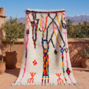 Detail eines Azilal Teppichs mit buntem Berber-Muster auf cremefarbener Wolle